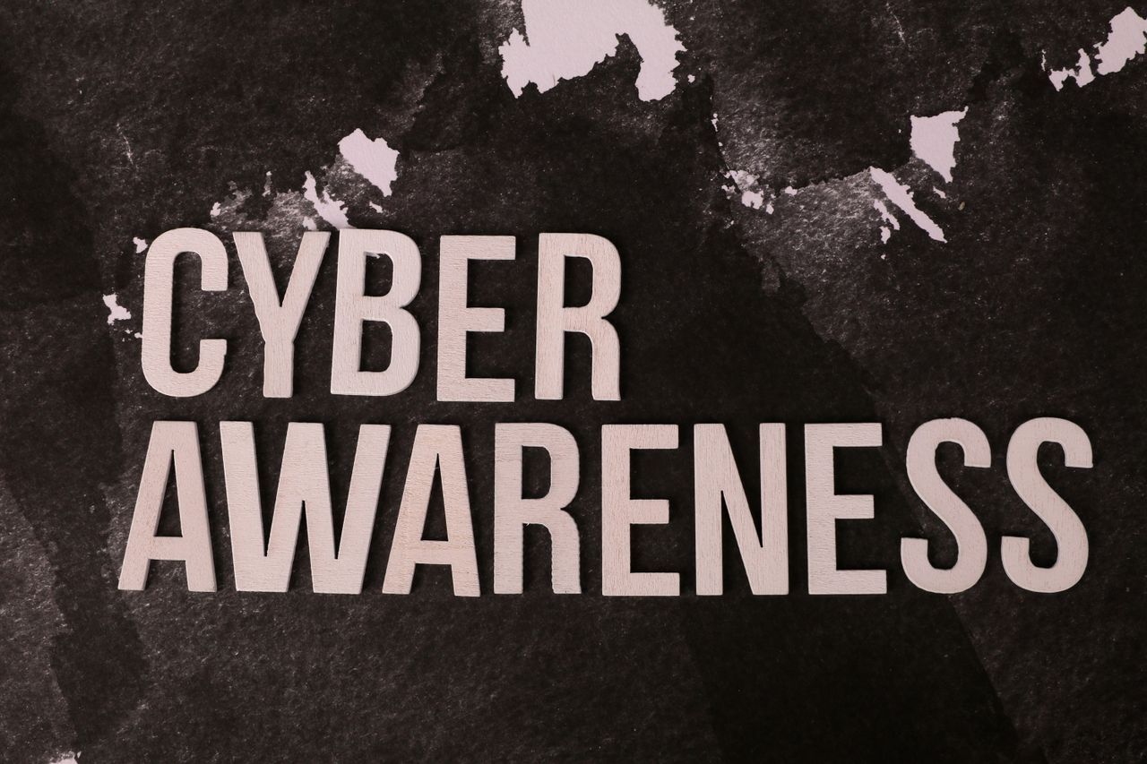 Stylized text Cyber Awareness over abstract dark background, highlighting online safety theme.